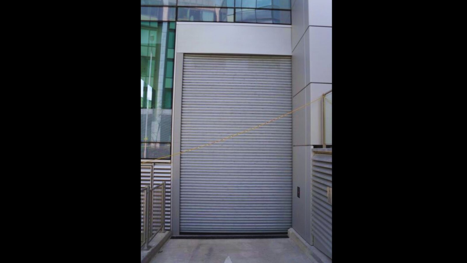 Silver metal roller shutter door on a outdoor storage shed.