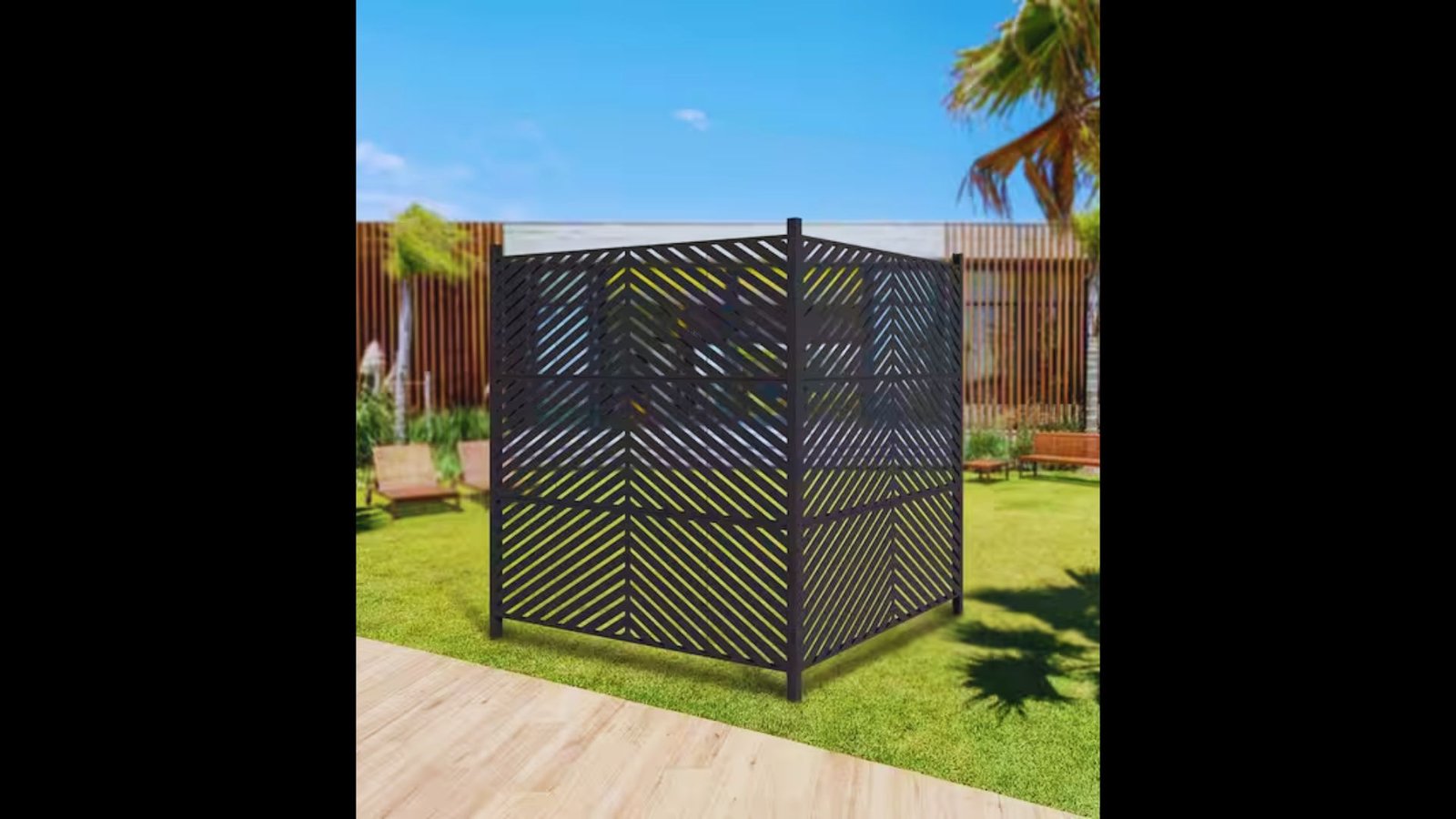 Decorative dark wooden lattice fence panels forming an outdoor enclosure on a green lawn in a backyard.