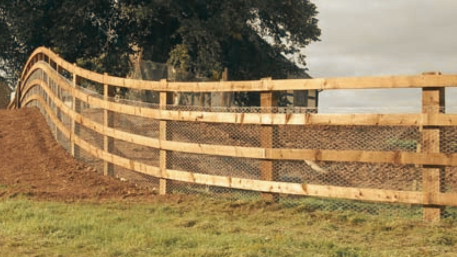 Wooden rail fence creating consistent steps along sloped terrain