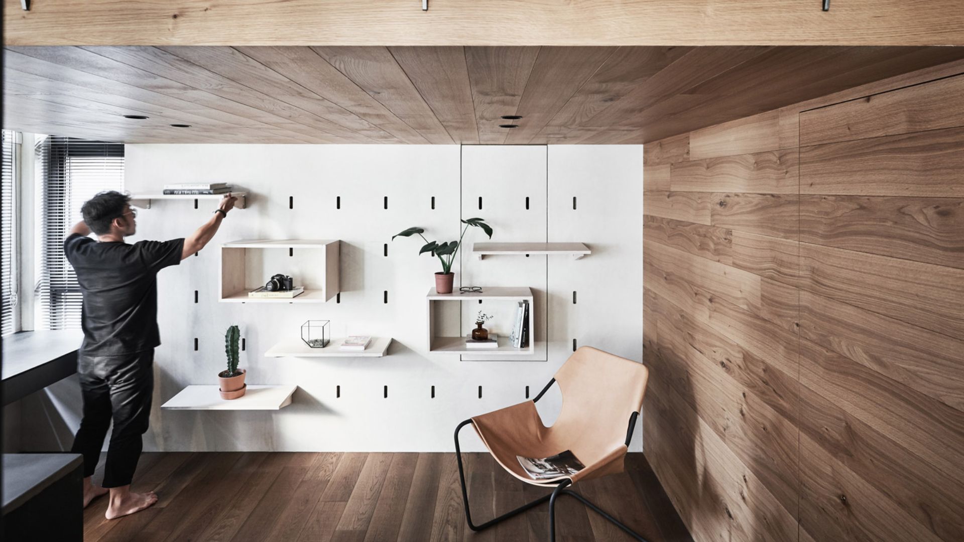 Smart storage-centered shed tiny house layout - modular peg wall shelves, wood paneling and minimalist chair