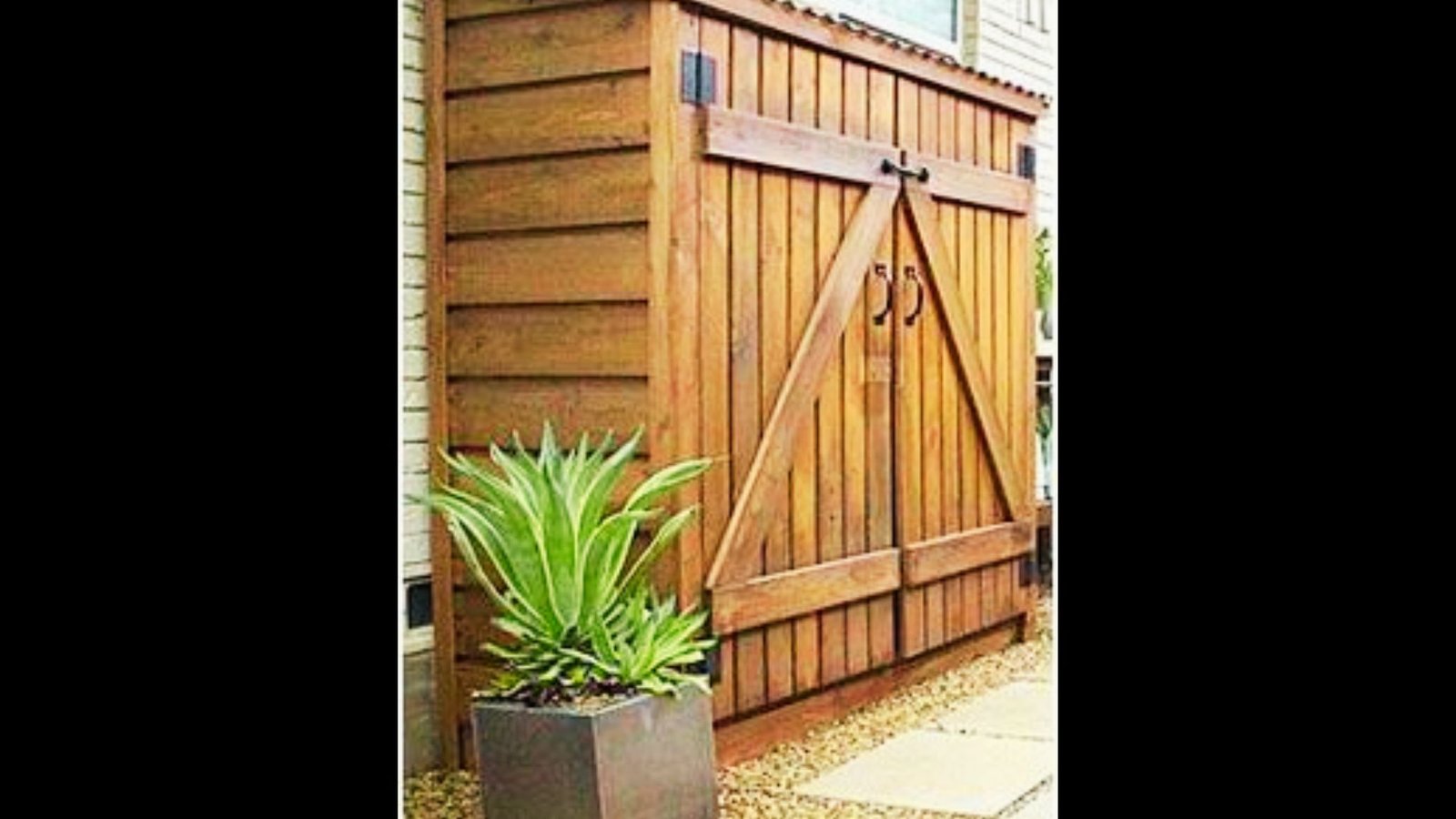 Wooden lean-to pool equipment shed built against a house wall with double doors and a corrugated metal roof.