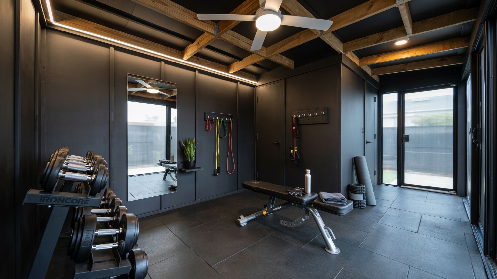Home gym inside shed with rubber flooring, weights, and exercise equipment