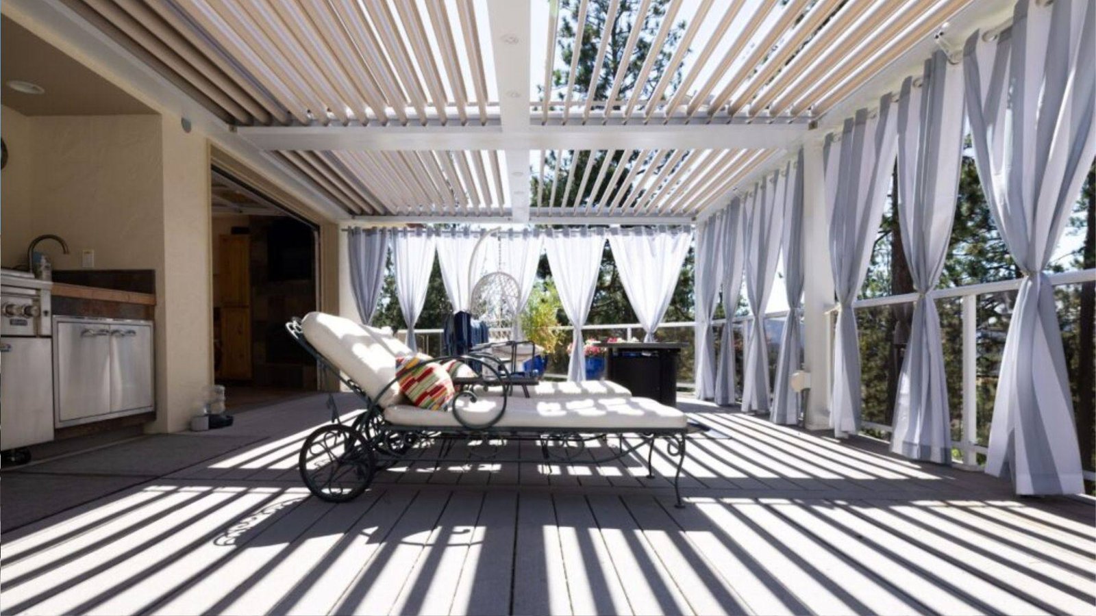 Close-up of light wood pergola corner joint with diagonal brace, red screws, and open sky background.