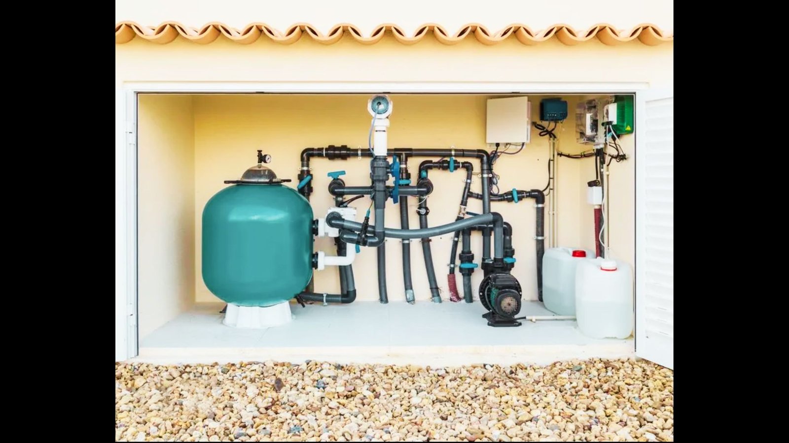 Pool equipment room with blue filter tank, pump, PVC pipes, and wall-mounted control panel.