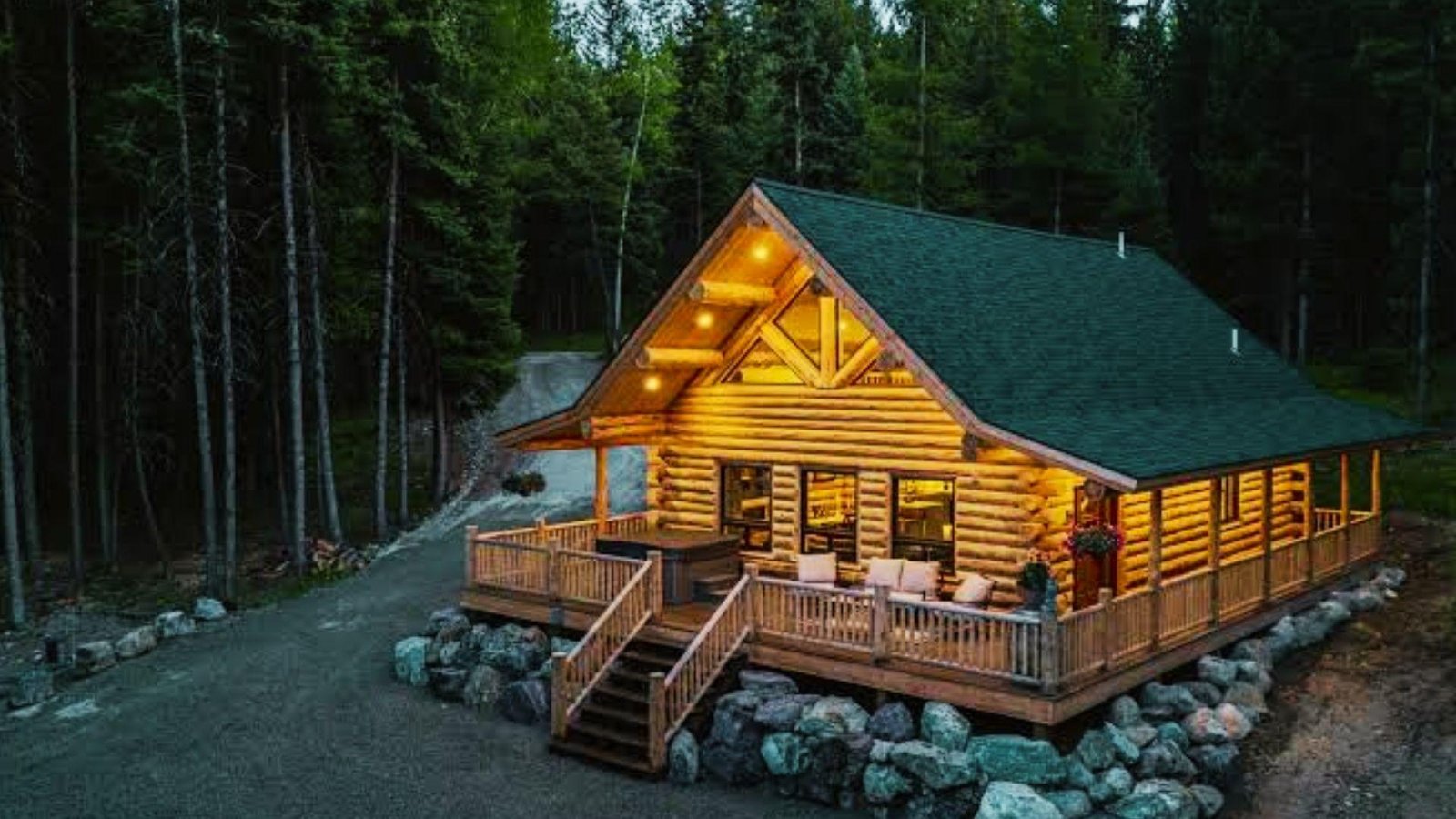 A rustic log cabin nestled in the woods, featuring a wooden deck surrounded by tall trees.