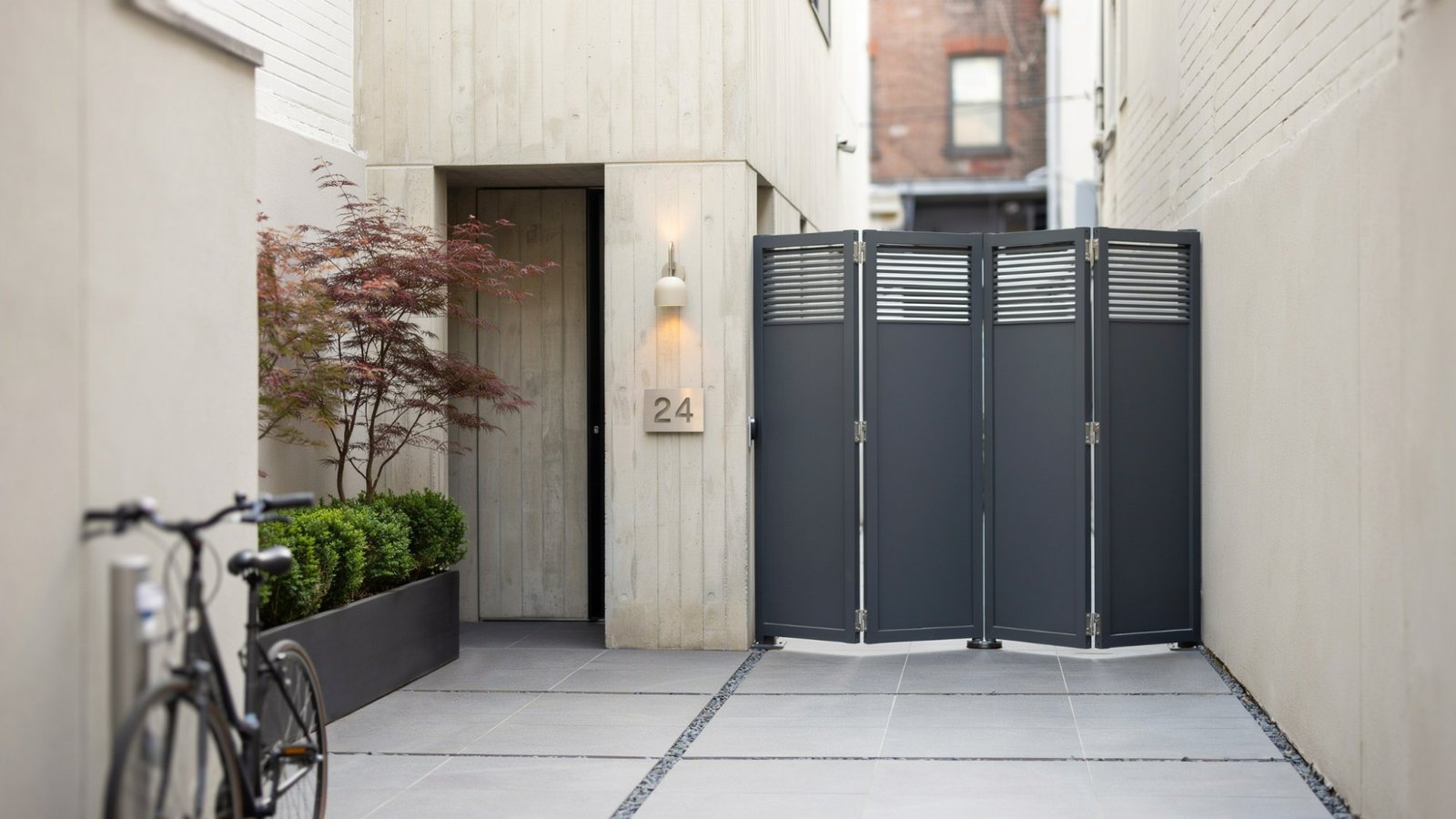 Space-saving folding courtyard gate with modern metal panels.