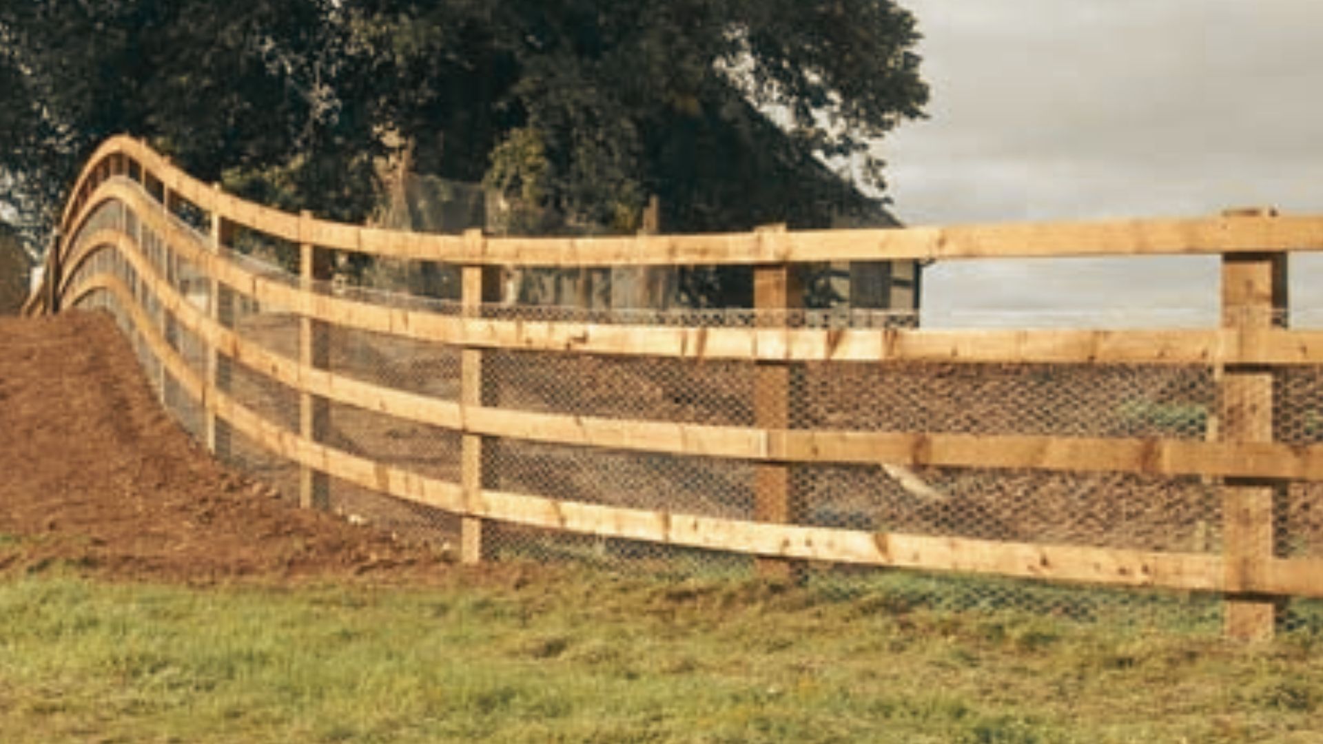 Wooden rail fence creating consistent steps along sloped terrain