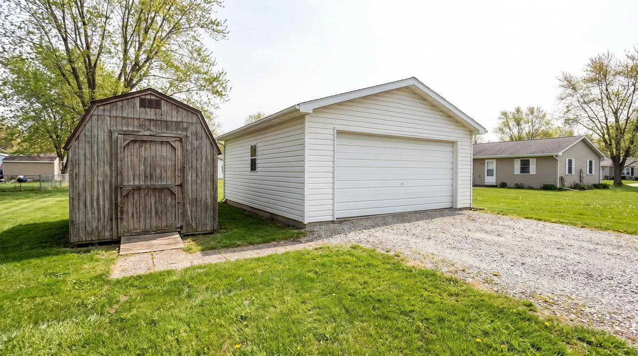 Small shed and larger garage shown side by side on a property