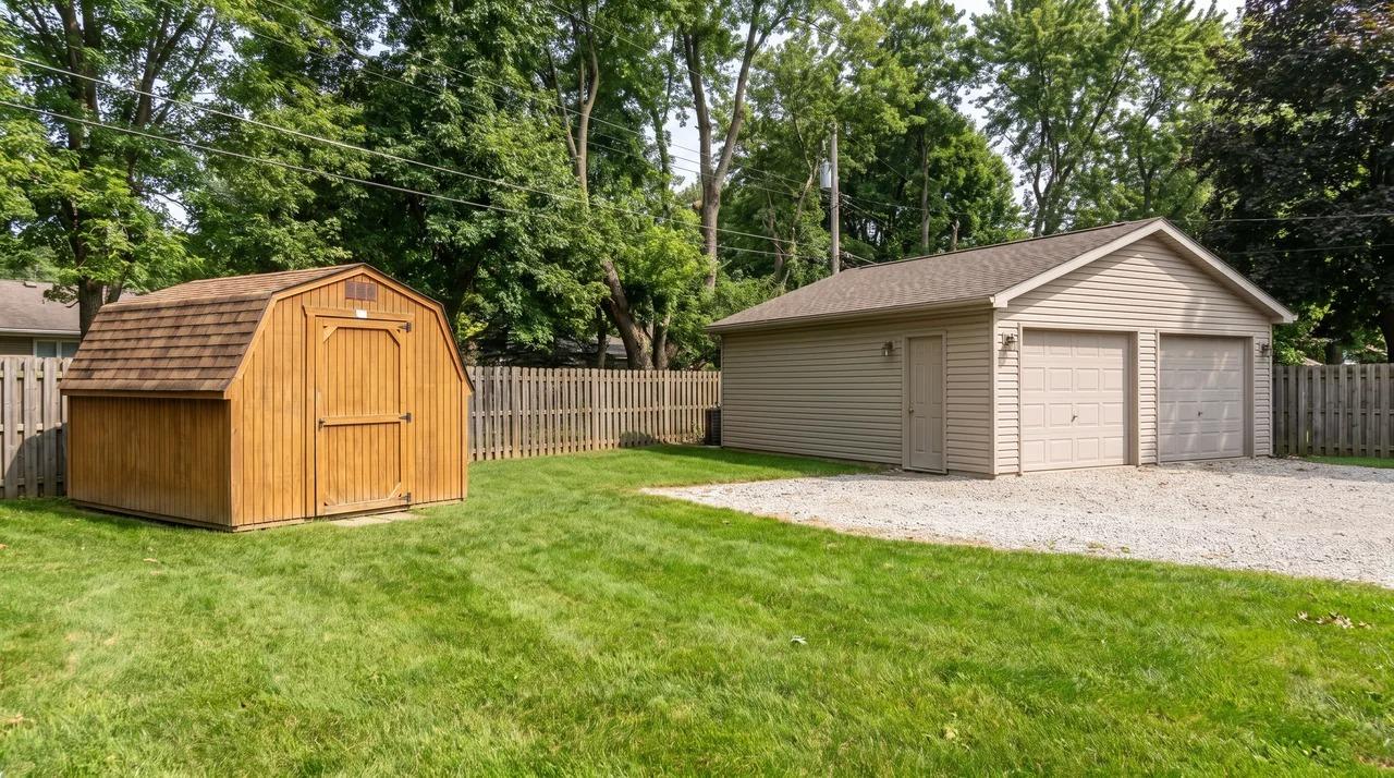 Small standalone shed and larger garage on a residential property