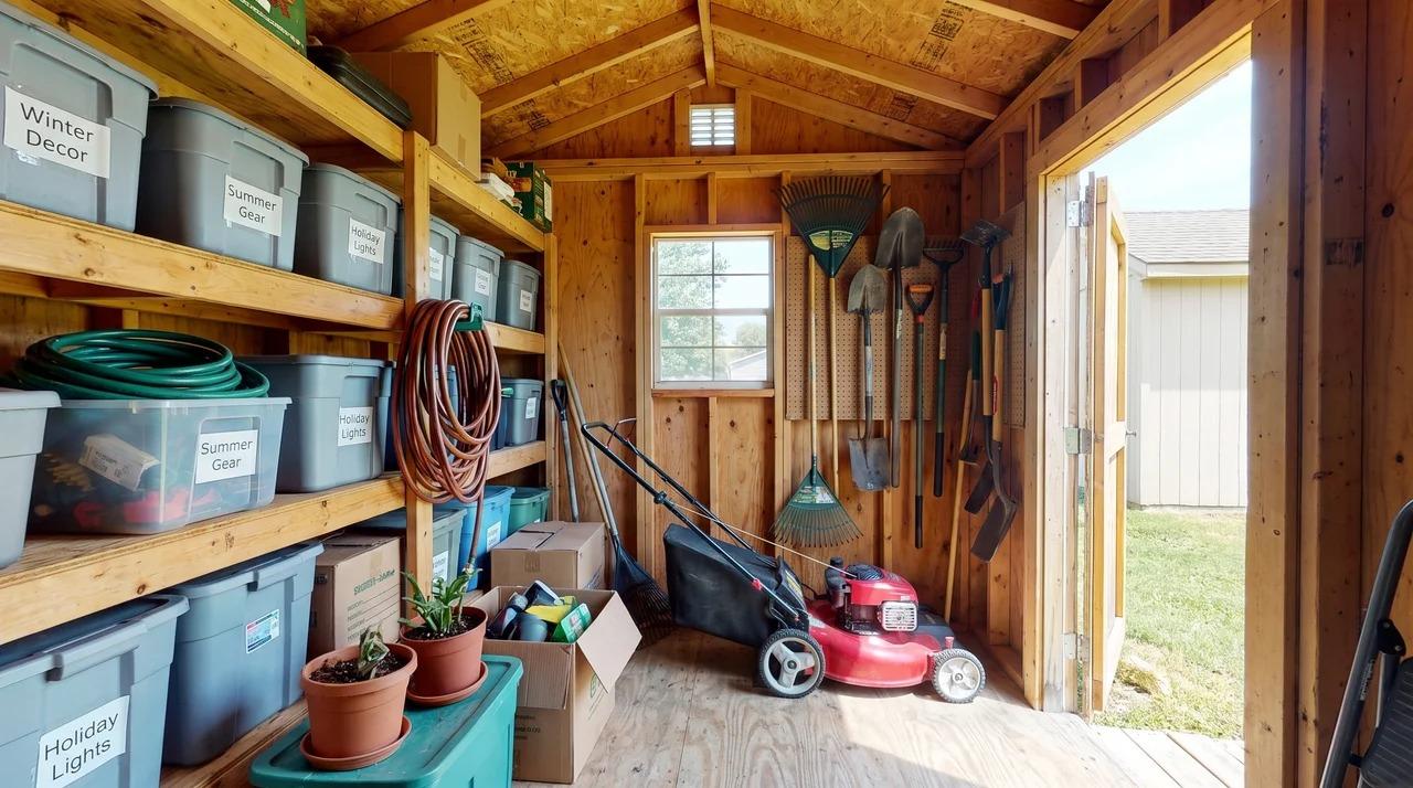 Small shed storing garden tools, a lawnmower, and seasonal items