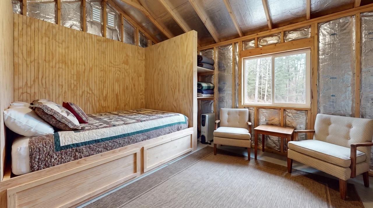 Shed guest space with sleeping area, sitting space, window, and insulated walls
