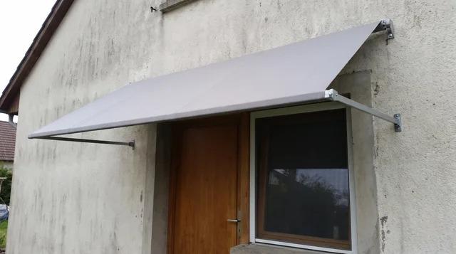 Awning projecting from a building's exterior wall above a window and door