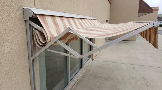 Retractable awning partly folded back against a building's exterior wallFile name-retractable-awning-folded-against-wall