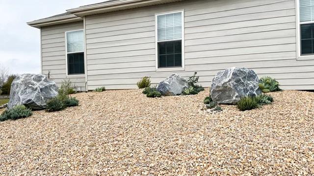 Front yard of crushed gravel with large quarried boulders and a few plants in place of a lawnFile name-gravel-boulder-lawn-replacement